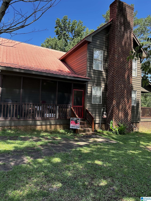 76 Goggins Dr, Montevallo, AL 35115 - back of house featuring a sunroom, a yard, a metal roof, and a chimney