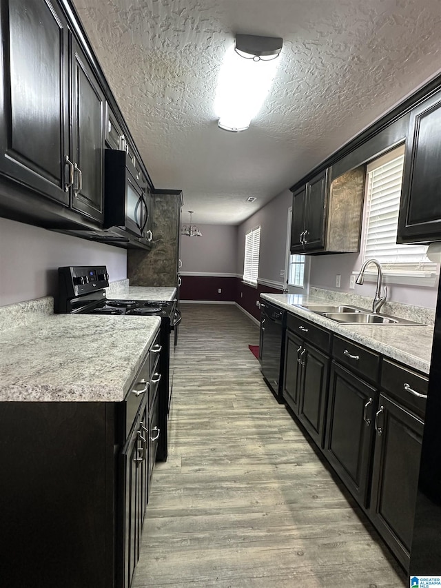 426 Bailey Rd, Weaver, AL 36277 - kitchen featuring black appliances, dark cabinetry, light wood-type flooring, and a textured ceiling