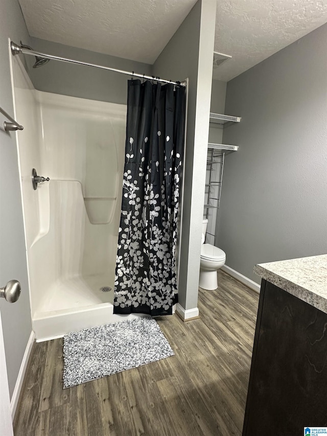 426 Bailey Rd, Weaver, AL 36277 - bathroom with wood finished floors, a shower stall, vanity, and a textured ceiling