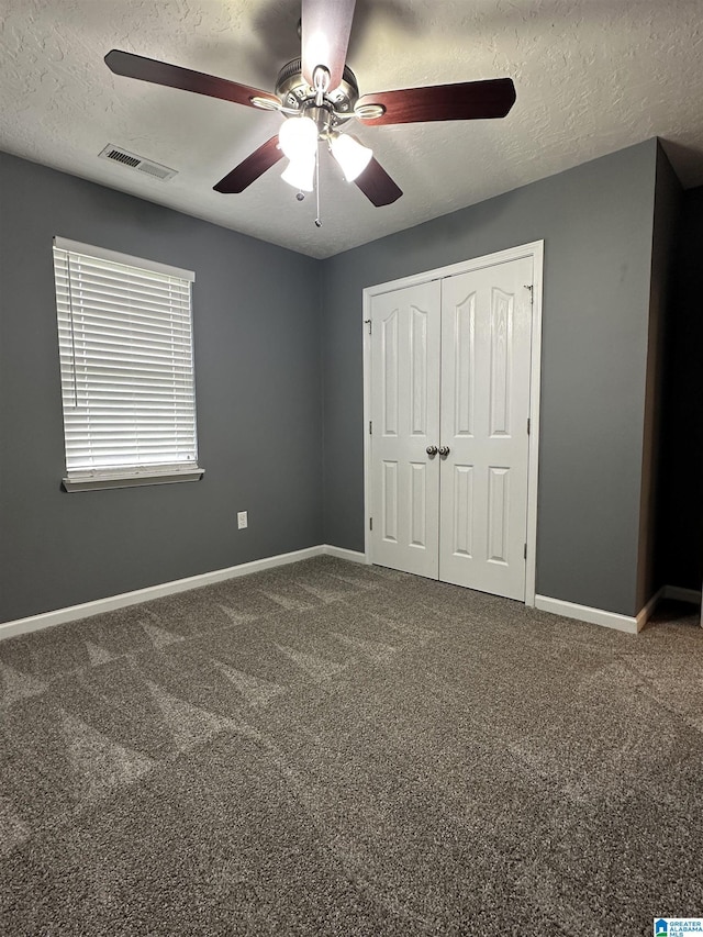 426 Bailey Rd, Weaver, AL 36277 - unfurnished bedroom featuring a textured ceiling, carpet, a closet, and ceiling fan