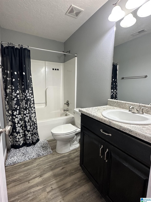 426 Bailey Rd, Weaver, AL 36277 - full bathroom featuring wood finished floors, vanity, a textured ceiling, and shower / bathtub combination with curtain