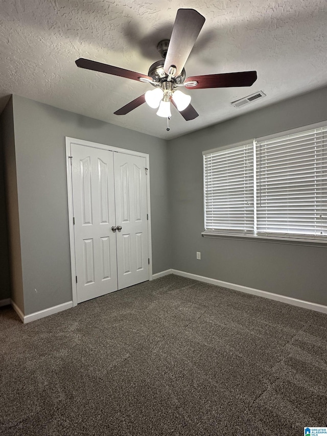 426 Bailey Rd, Weaver, AL 36277 - unfurnished bedroom with a textured ceiling, carpet flooring, a closet, and ceiling fan