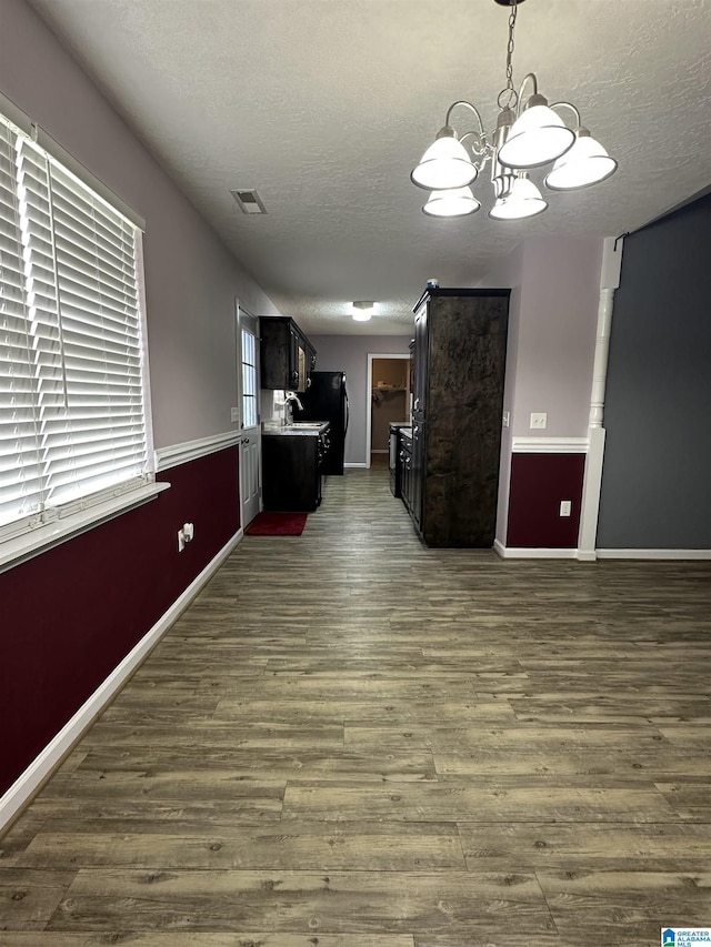 426 Bailey Rd, Weaver, AL 36277 - unfurnished living room with a textured ceiling, dark wood finished floors, and a chandelier