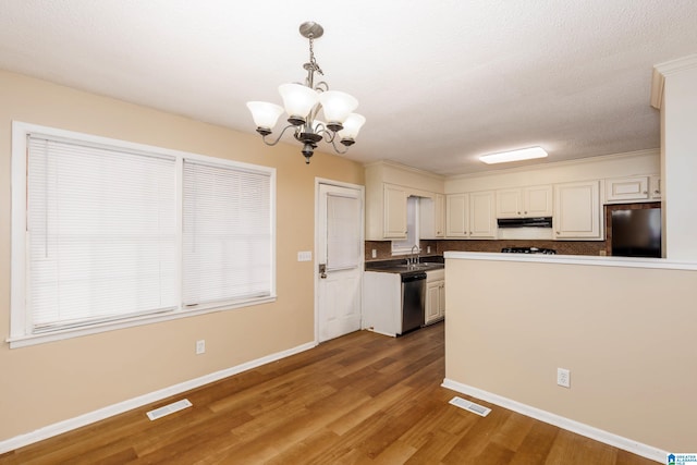 2517 Wright Cir, Birmingham, AL 35235 - kitchen with refrigerator, dishwasher, a chandelier, wood finished floors, and under cabinet range hood