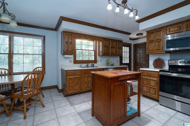 3518 William And Mary Rd, Hoover, AL 35216 - kitchen with appliances with stainless steel finishes, butcher block counters, crown molding, brown cabinetry, and a kitchen island