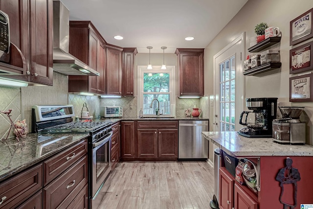 2912 Monte Deste Dr, Hoover, AL 35216 - kitchen featuring appliances with stainless steel finishes, wall chimney exhaust hood, open shelves, light wood-style flooring, and dark stone counters
