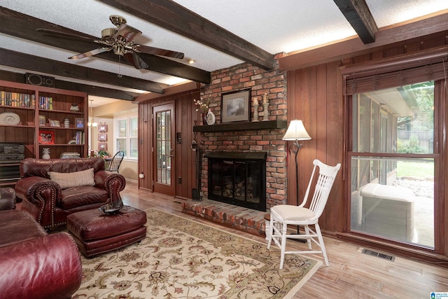 2912 Monte Deste Dr, Hoover, AL 35216 - living area with beam ceiling, a brick fireplace, wood finished floors, wood walls, and a ceiling fan