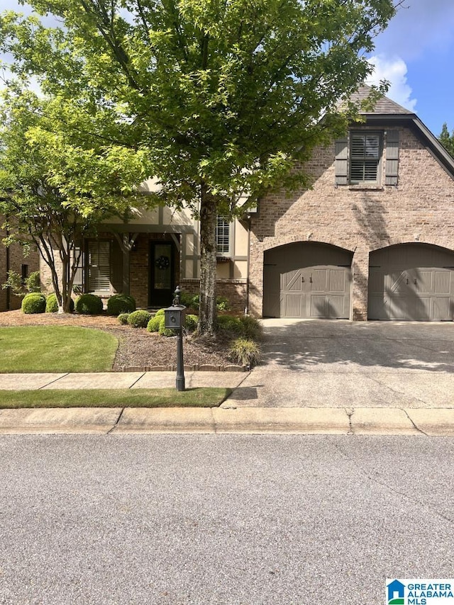 1664 Warren Ln, Vestavia Hills, AL 35243 - obstructed view of property featuring a garage, asphalt driveway, and brick siding