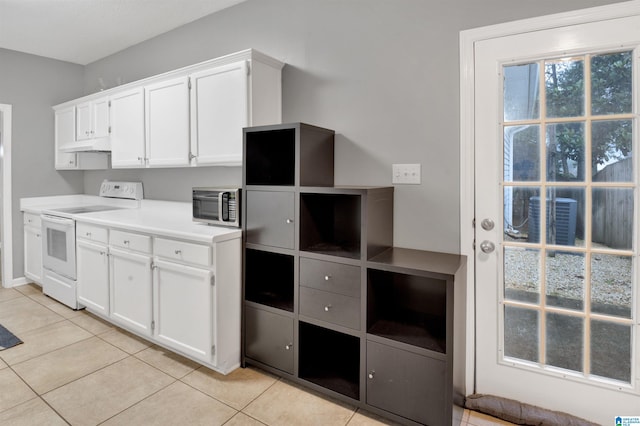 4033 Saddle Run Cir, Pelham, AL 35124 - kitchen with electric stove, stainless steel microwave, light tile patterned flooring, white cabinetry, and under cabinet range hood