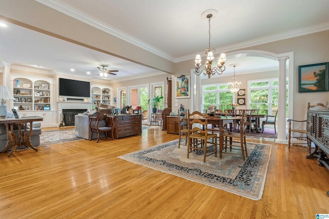 1007 Eagle Hill Dr, Birmingham, AL 35242 - dining area with light wood finished floors, a fireplace, a chandelier, arched walkways, and a ceiling fan