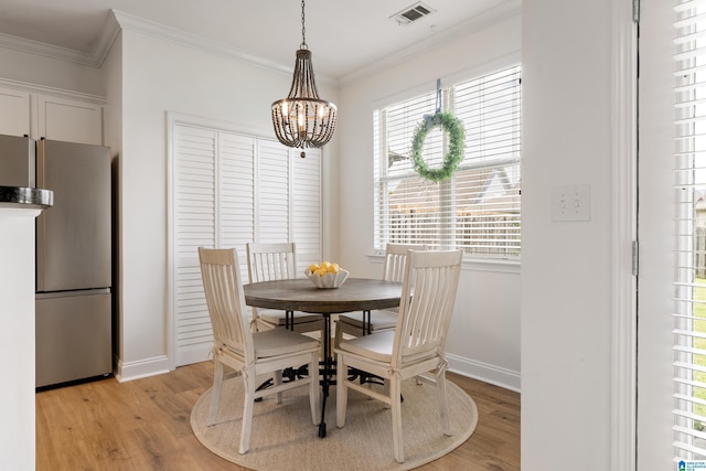 1185 Overlook Dr, Trussville, AL 35173 - dining space featuring a chandelier, light wood-style floors, ornamental molding, and healthy amount of natural light