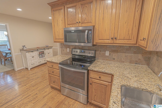 2191 Whiting Rd, Hoover, AL 35216 - kitchen with appliances with stainless steel finishes, light wood-style flooring, tasteful backsplash, light stone countertops, and recessed lighting