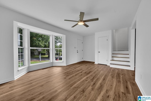 8312 Country Cir, Pinson, AL 35126 - unfurnished living room featuring wood finished floors, a ceiling fan, and stairway