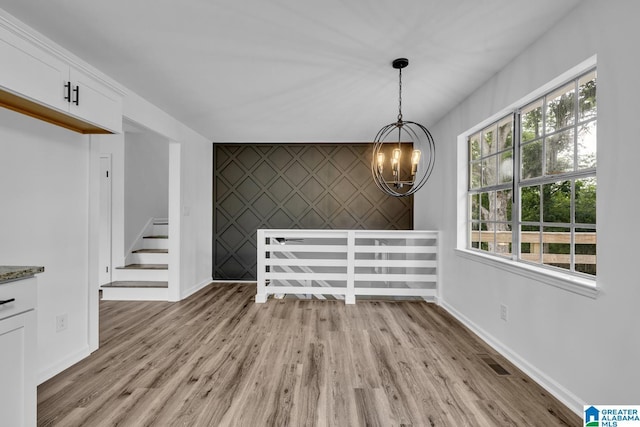 8312 Country Cir, Pinson, AL 35126 - unfurnished dining area with an accent wall, a chandelier, and light wood-style flooring
