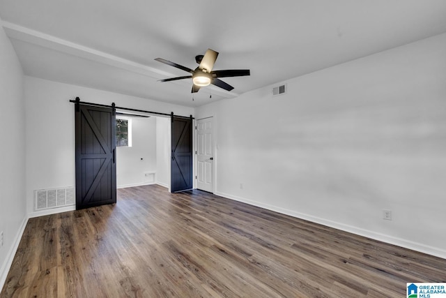 8312 Country Cir, Pinson, AL 35126 - unfurnished bedroom featuring a barn door, wood finished floors, and a ceiling fan