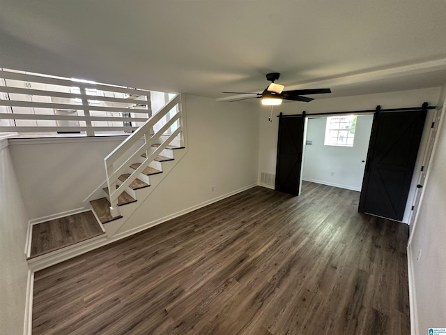 8312 Country Cir, Pinson, AL 35126 - unfurnished living room with a barn door, dark wood-style floors, a ceiling fan, and stairs