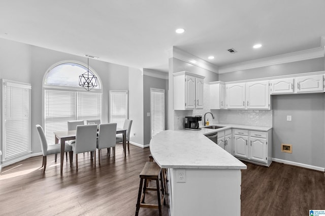 4652 Lake Valley Dr, Hoover, AL 35244 - kitchen featuring white cabinetry, ornamental molding, dark wood-style floors, a breakfast bar area, and backsplash