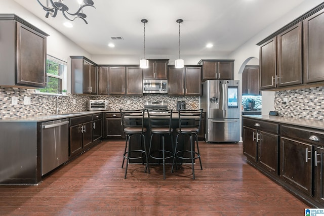 5432 Parkside Cir, Hoover, AL 35244 - kitchen featuring stainless steel appliances, dark brown cabinets, tasteful backsplash, arched walkways, and hanging light fixtures