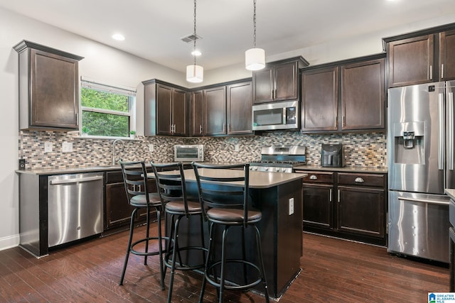 5432 Parkside Cir, Hoover, AL 35244 - kitchen with stainless steel appliances, a center island, dark brown cabinetry, a breakfast bar, and dark wood-style flooring