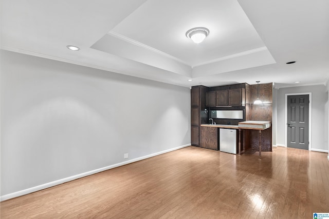 5521 Magnolia Trce, Hoover, AL 35244 - kitchen featuring a tray ceiling, dark brown cabinets, dishwasher, light wood-type flooring, and ornamental molding