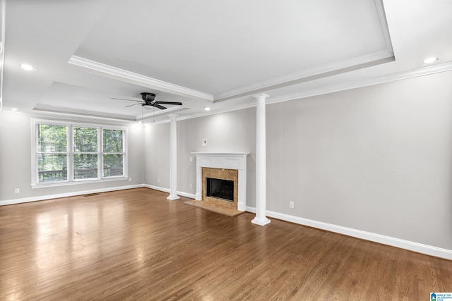 5521 Magnolia Trce, Hoover, AL 35244 - unfurnished living room featuring a raised ceiling, ornate columns, wood finished floors, a fireplace, and crown molding