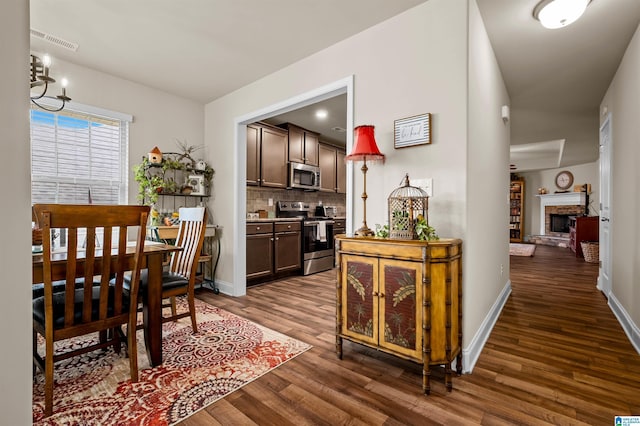 143 Hidden Trace Ct, Montevallo, AL 35115 - dining room featuring dark wood finished floors, a brick fireplace, and a chandelier