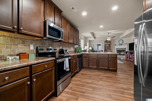143 Hidden Trace Ct, Montevallo, AL 35115 - kitchen featuring appliances with stainless steel finishes, open floor plan, ceiling fan, a peninsula, and light wood finished floors