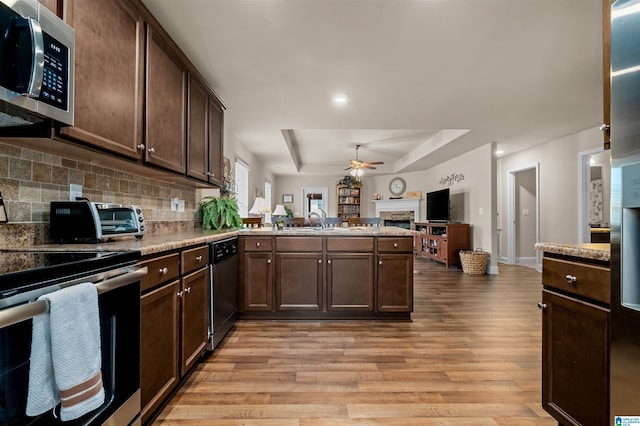 143 Hidden Trace Ct, Montevallo, AL 35115 - kitchen featuring appliances with stainless steel finishes, a fireplace, a raised ceiling, ceiling fan, and open floor plan
