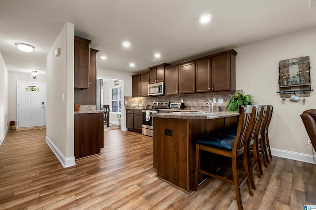 143 Hidden Trace Ct, Montevallo, AL 35115 - kitchen featuring stainless steel appliances, tasteful backsplash, dark brown cabinets, wood finished floors, and recessed lighting