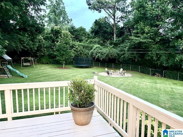 2713 Altadena Lake Rd, Birmingham, AL 35243 - wooden deck featuring a trampoline, a playground, a fenced backyard, and an outdoor fire pit