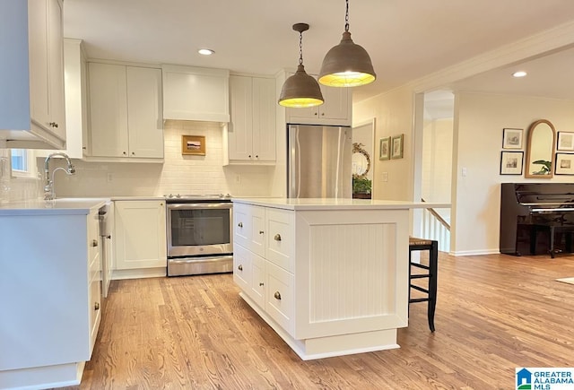2713 Altadena Lake Rd, Birmingham, AL 35243 - kitchen with stainless steel appliances, a kitchen island, decorative backsplash, light wood finished floors, and light countertops