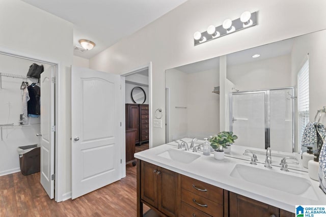 5633 Park Side Rd, Hoover, AL 35244 - bathroom with double vanity, a walk in closet, wood finished floors, and a shower stall