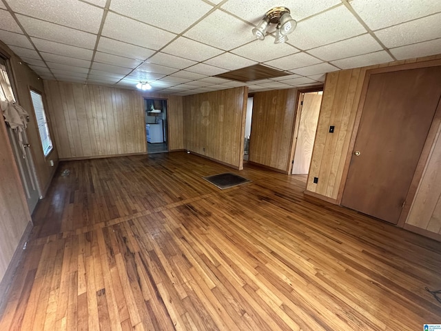 2910 Old Gadsden Hwy, Anniston, AL 36206 - unfurnished living room with hardwood / wood-style floors, a drop ceiling, and wooden walls