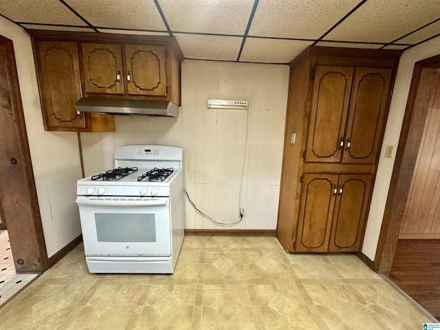 2910 Old Gadsden Hwy, Anniston, AL 36206 - kitchen featuring white range with gas cooktop, under cabinet range hood, brown cabinets, and a paneled ceiling