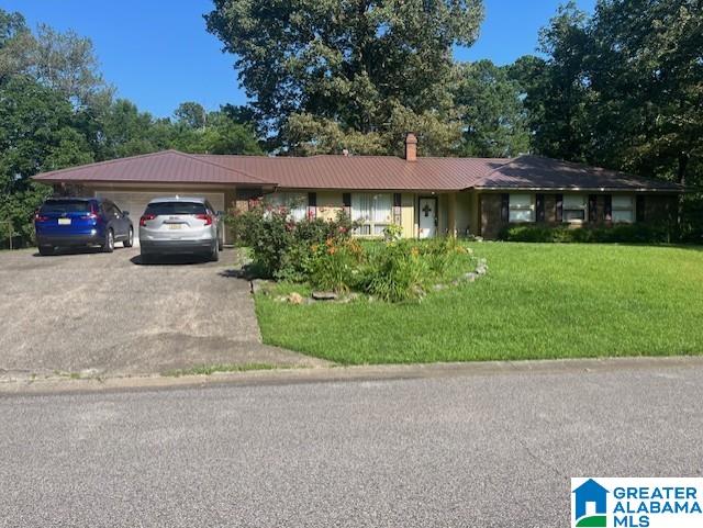 2215 Vicki Dr, Birmingham, AL 35235 - single story home featuring an attached garage, a front yard, a chimney, driveway, and a metal roof
