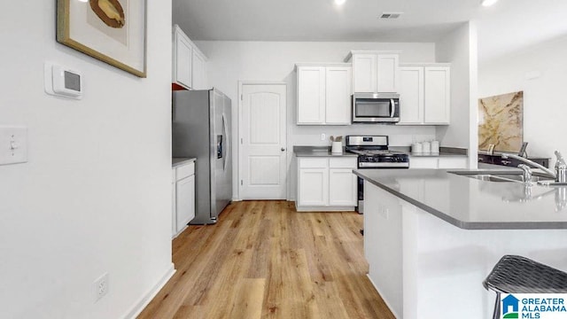 545 Sterling Pl, Odenville, AL 35120 - kitchen with stainless steel appliances, light wood finished floors, and white cabinets