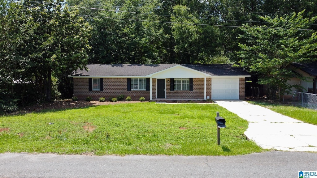 401 Ashley Dr, Pell City, AL 35125 - ranch-style home with brick siding, driveway, an attached garage, and a front lawn