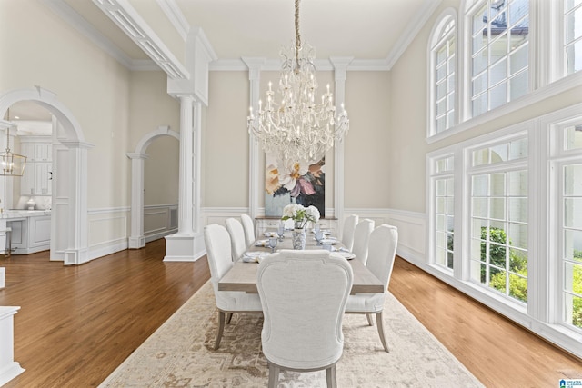 5615 Canongate Ln, Hoover, AL 35242 - dining room featuring a chandelier, wood finished floors, ornamental molding, decorative columns, and a towering ceiling