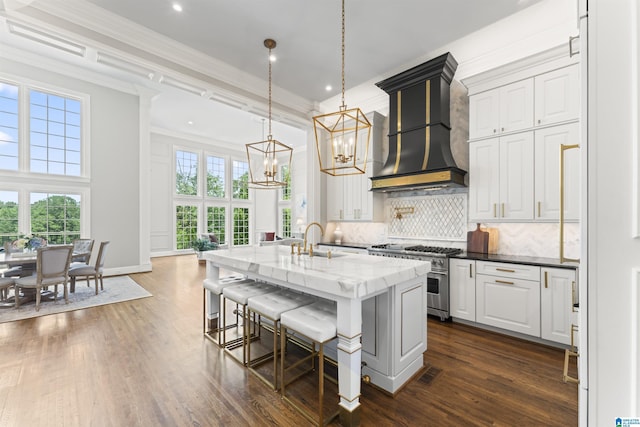 5615 Canongate Ln, Hoover, AL 35242 - kitchen with high end range, custom exhaust hood, a chandelier, dark wood-style flooring, and crown molding