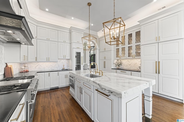 5615 Canongate Ln, Hoover, AL 35242 - kitchen with a chandelier, exhaust hood, appliances with stainless steel finishes, glass insert cabinets, and tasteful backsplash