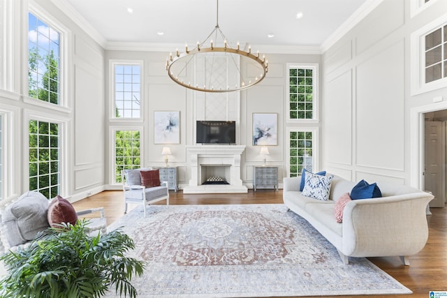 5615 Canongate Ln, Hoover, AL 35242 - living area featuring a decorative wall, wood finished floors, ornamental molding, a chandelier, and a fireplace with raised hearth
