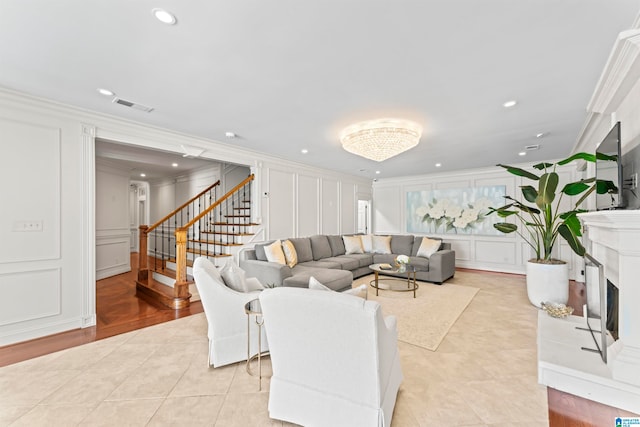 5615 Canongate Ln, Hoover, AL 35242 - living area with a decorative wall, crown molding, stairway, a fireplace with raised hearth, and light tile patterned floors