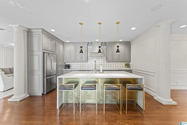 5615 Canongate Ln, Hoover, AL 35242 - kitchen with stainless steel refrigerator, ornate columns, gray cabinets, wall chimney exhaust hood, and a decorative wall