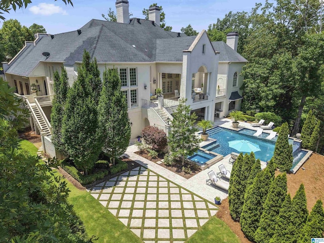 5615 Canongate Ln, Hoover, AL 35242 - back of house featuring stairway, stucco siding, a chimney, a patio area, and a pool with connected hot tub