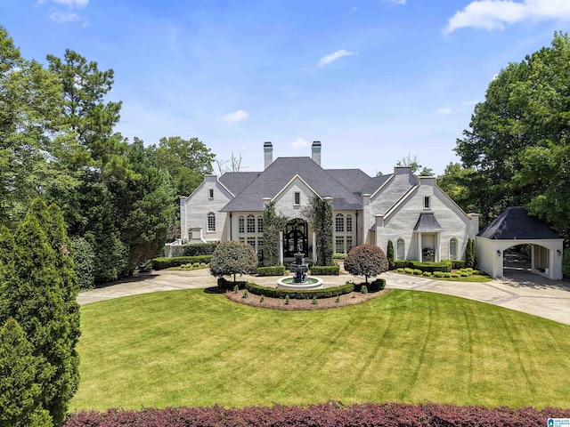 5615 Canongate Ln, Hoover, AL 35242 - french provincial home with a front yard, curved driveway, stone siding, and a chimney