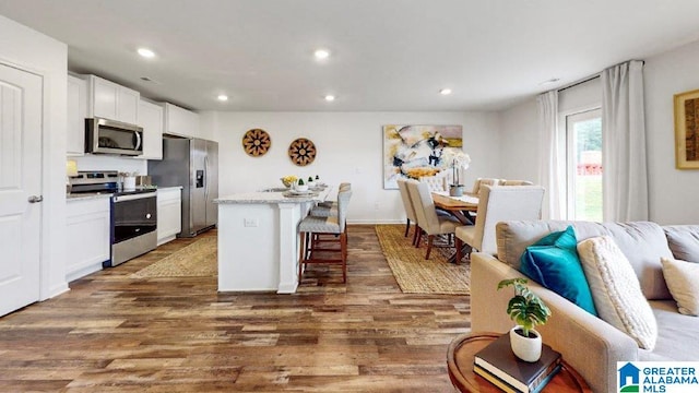 365 Koslin Loop, Calera, AL 35040 - kitchen with stainless steel appliances, a kitchen bar, white cabinetry, wood finished floors, and recessed lighting