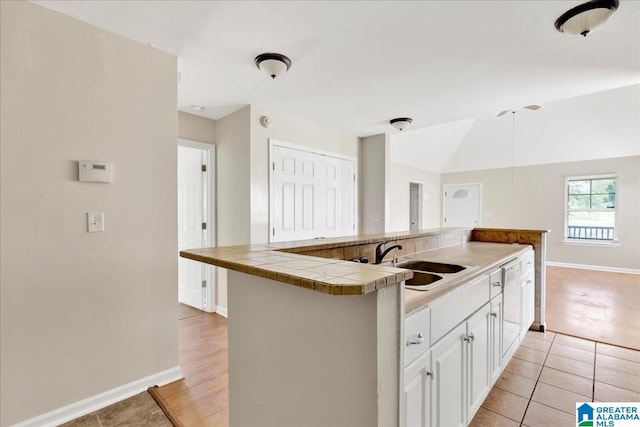1324 Fulton Ave SW, Birmingham, AL 35211 - kitchen featuring tile counters, dishwasher, white cabinetry, light tile patterned floors, and an island with sink