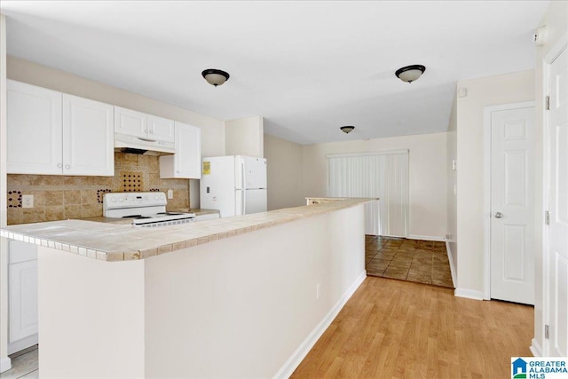 1324 Fulton Ave SW, Birmingham, AL 35211 - kitchen with white appliances, under cabinet range hood, decorative backsplash, white cabinetry, and tile counters