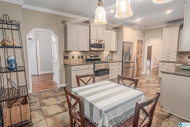 1813 Southpointe Cir, Hoover, AL 35244 - kitchen featuring appliances with stainless steel finishes, arched walkways, ornamental molding, decorative backsplash, and stone tile floors