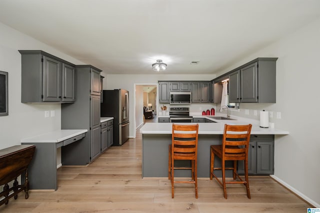 5904 Russet Meadows Way, Helena, AL 35244 - kitchen with appliances with stainless steel finishes, a peninsula, gray cabinetry, and light wood-style flooring